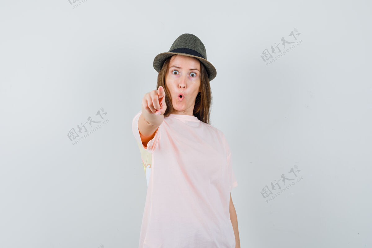 指向一位戴着粉色t恤帽子的年轻女士指着镜头 看上去很惊讶女性连衣裙时尚