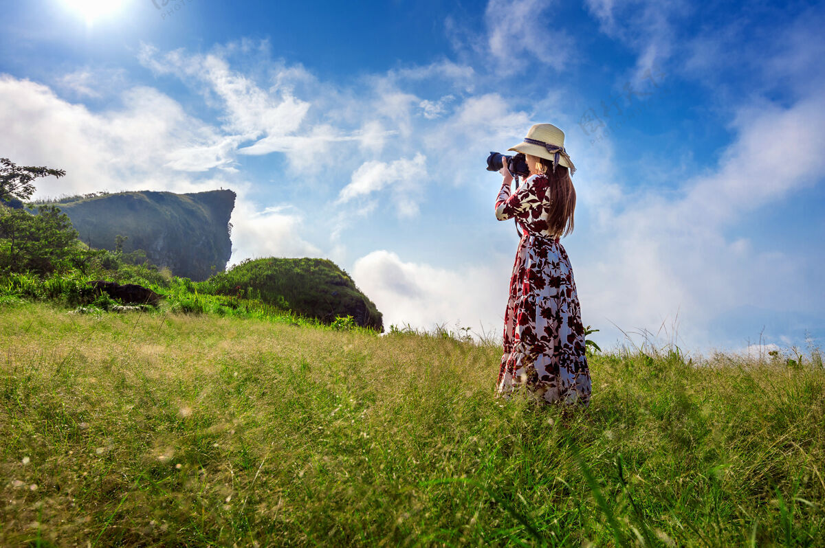 蒋泰国清莱府志发山 一位妇女站在草地上 手持相机拍照旅游理念采取远足泰国