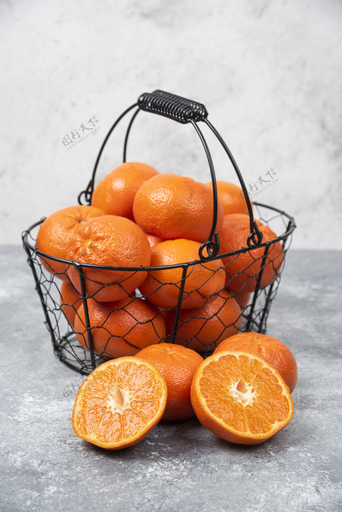 提神石桌上放着一个装满多汁橙子的金属黑色篮子柑橘异国情调热带