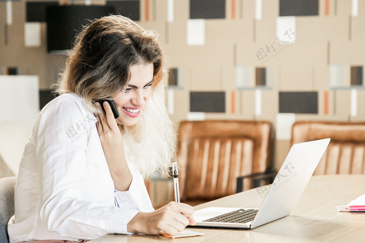 写下来愉快的经理在电话里和客户讨论项目讲话商务女性侧视
