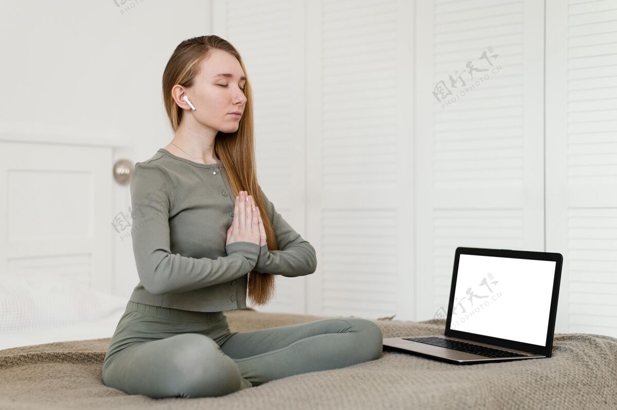 女性年轻女子坐在家里打坐 笔记本电脑在旁边瑜伽女人黑屏