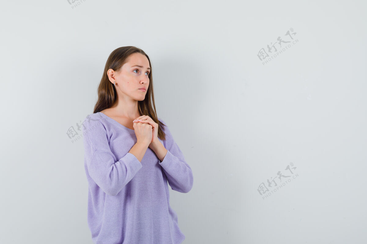 亚洲年轻的女性 双手合十放在胸前 身穿淡紫色上衣 看上去很平静前视图文本空间水疗深色完美