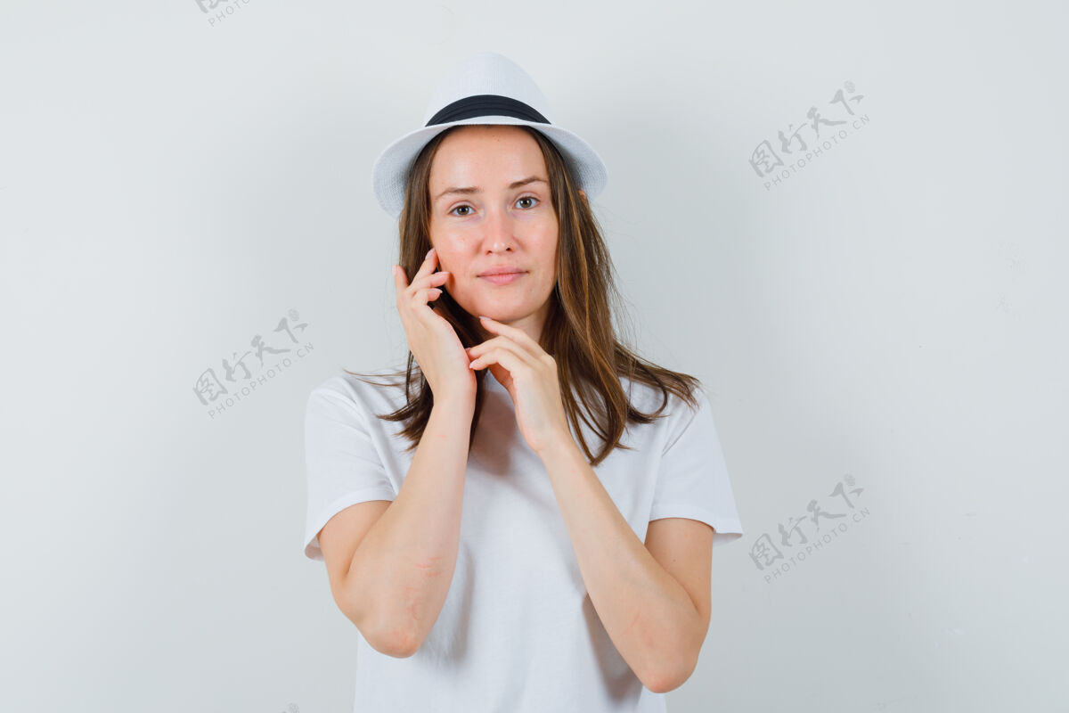 皮肤穿着白色t恤帽子的年轻女孩抚摸着脸上的皮肤 看上去很娇嫩孩子头发女性