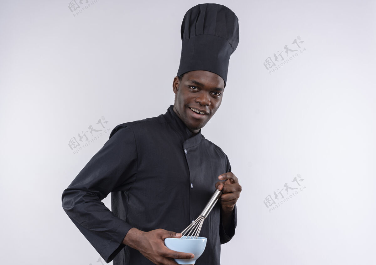 空间年轻快乐的非洲裔美国厨师 身着厨师制服 拿着碗 在白色地板上搅拌 留有复印空间制服复制烹饪