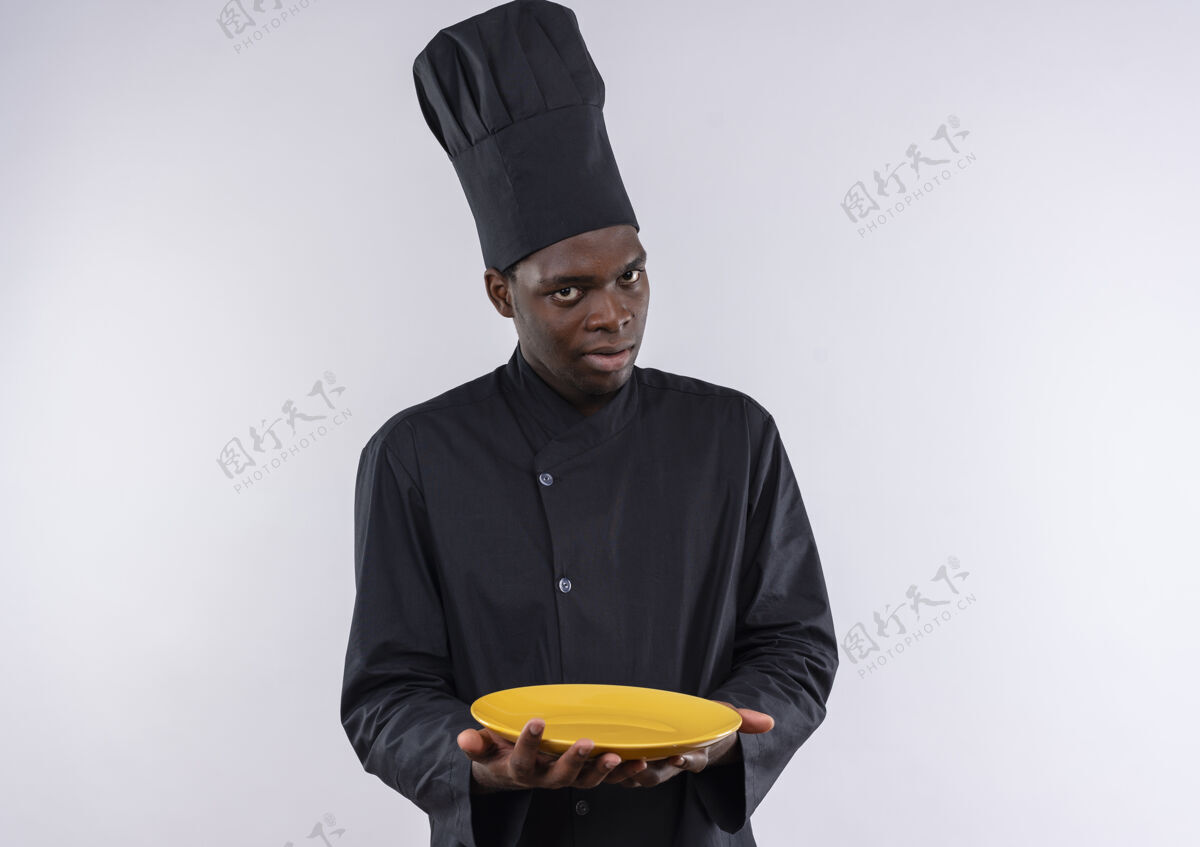 厨师年轻焦急的非洲裔美国厨师身着厨师制服 拿着白色的盘子 上面留有复印空间年轻焦虑持有