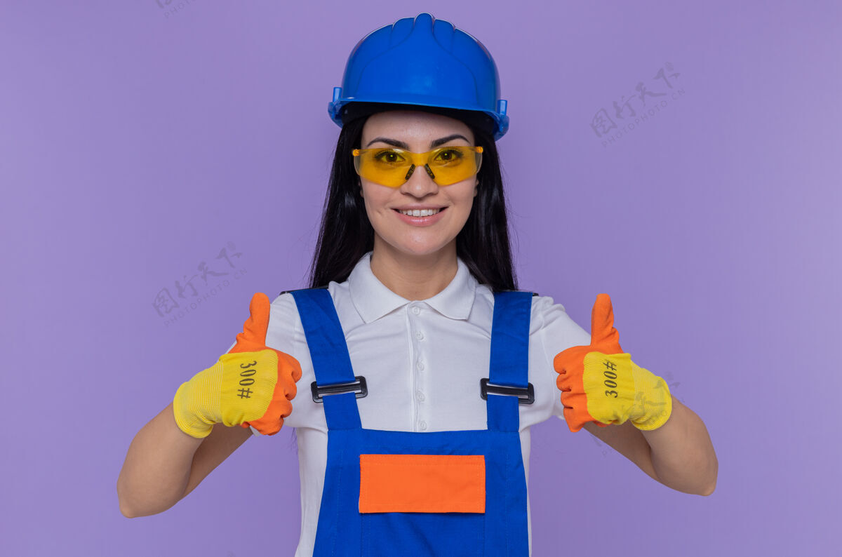 制服穿着施工制服 戴着安全帽 戴着橡胶手套的年轻建筑工人拇指手套安全