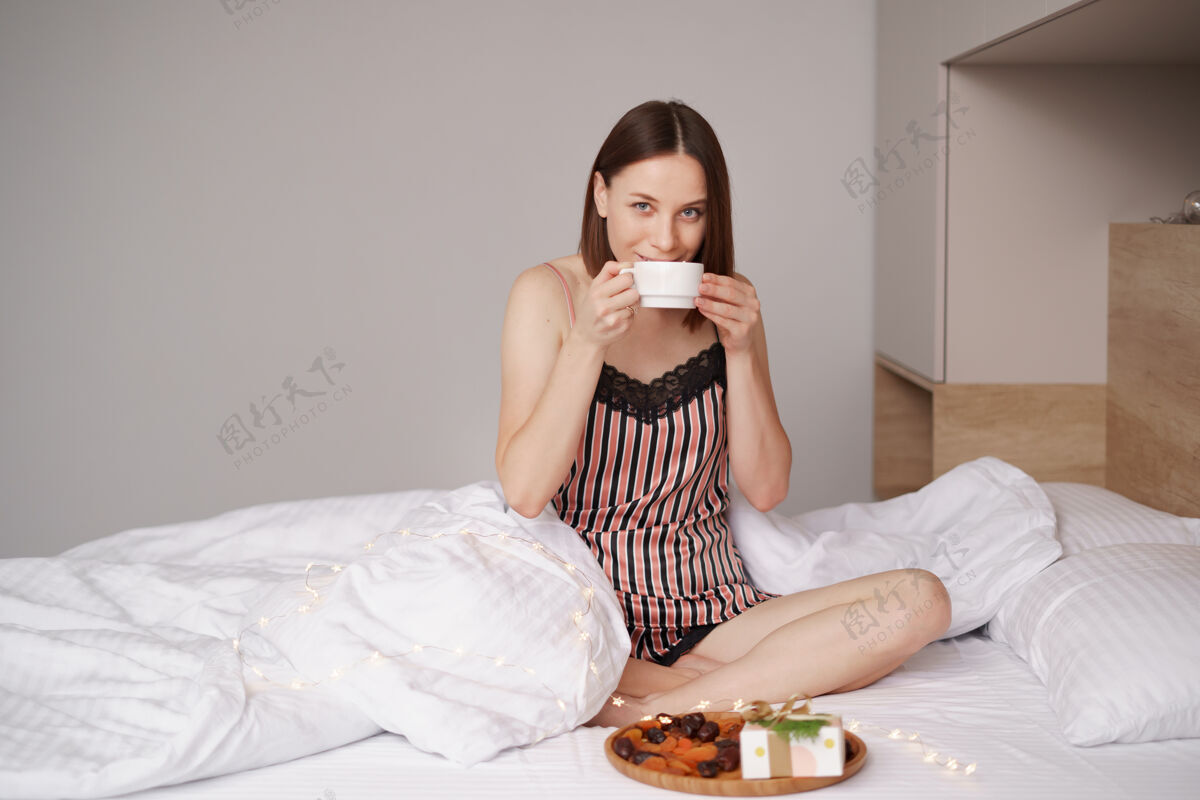 情人节女人们在床上享受着带着棉花糖的咖啡 身边还有礼物女人早晨美味