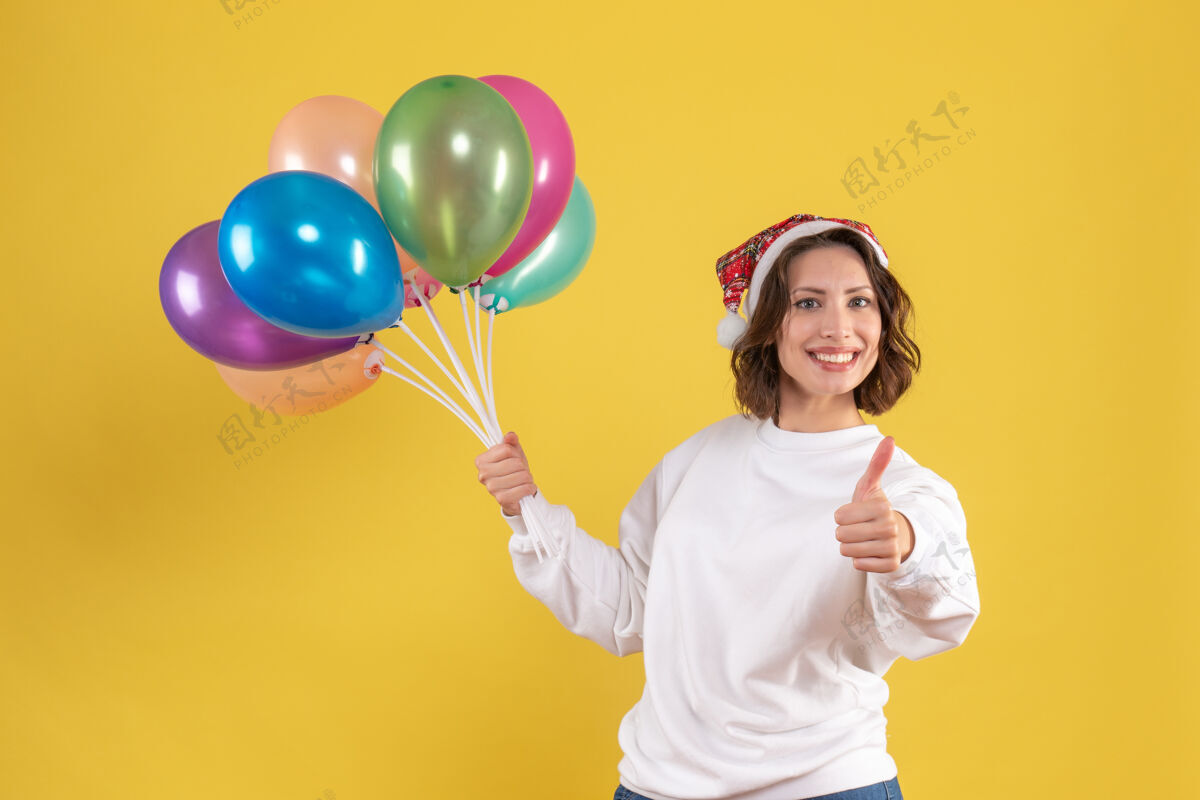 庆祝正面图：手持黄色气球的年轻女子女人蒲公英年轻女人