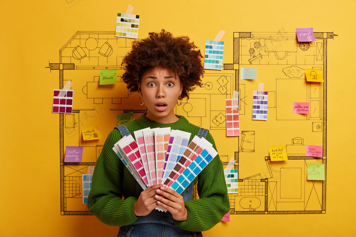 设计师美国黑人妇女拿着新公寓的颜色样本翻新民族油漆