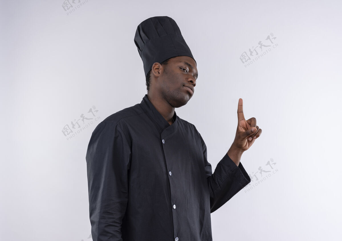 复制年轻自信的非洲裔美国厨师身着厨师制服 站在一旁 指着白色 留有复印空间年轻非裔美国人自信