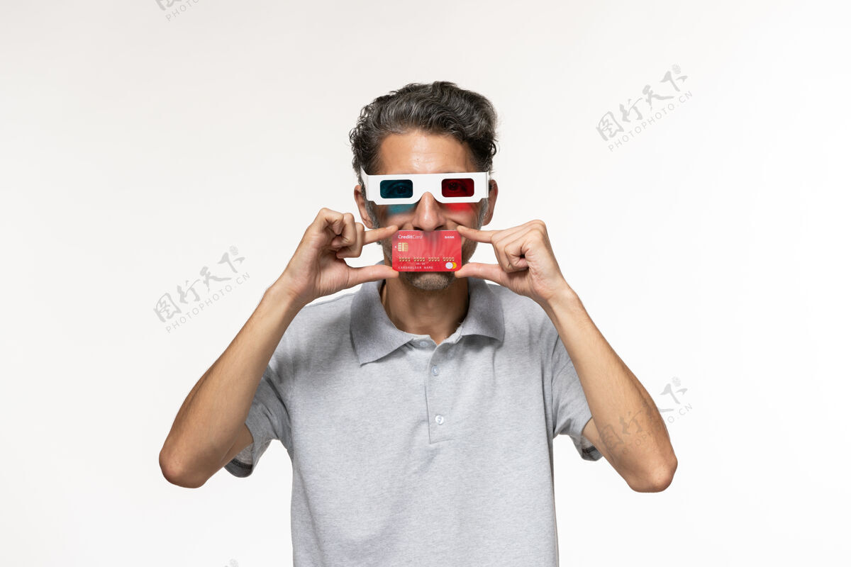 孤独正面图年轻男子手持红色银行卡戴着d墨镜在白色表面前面远程持有