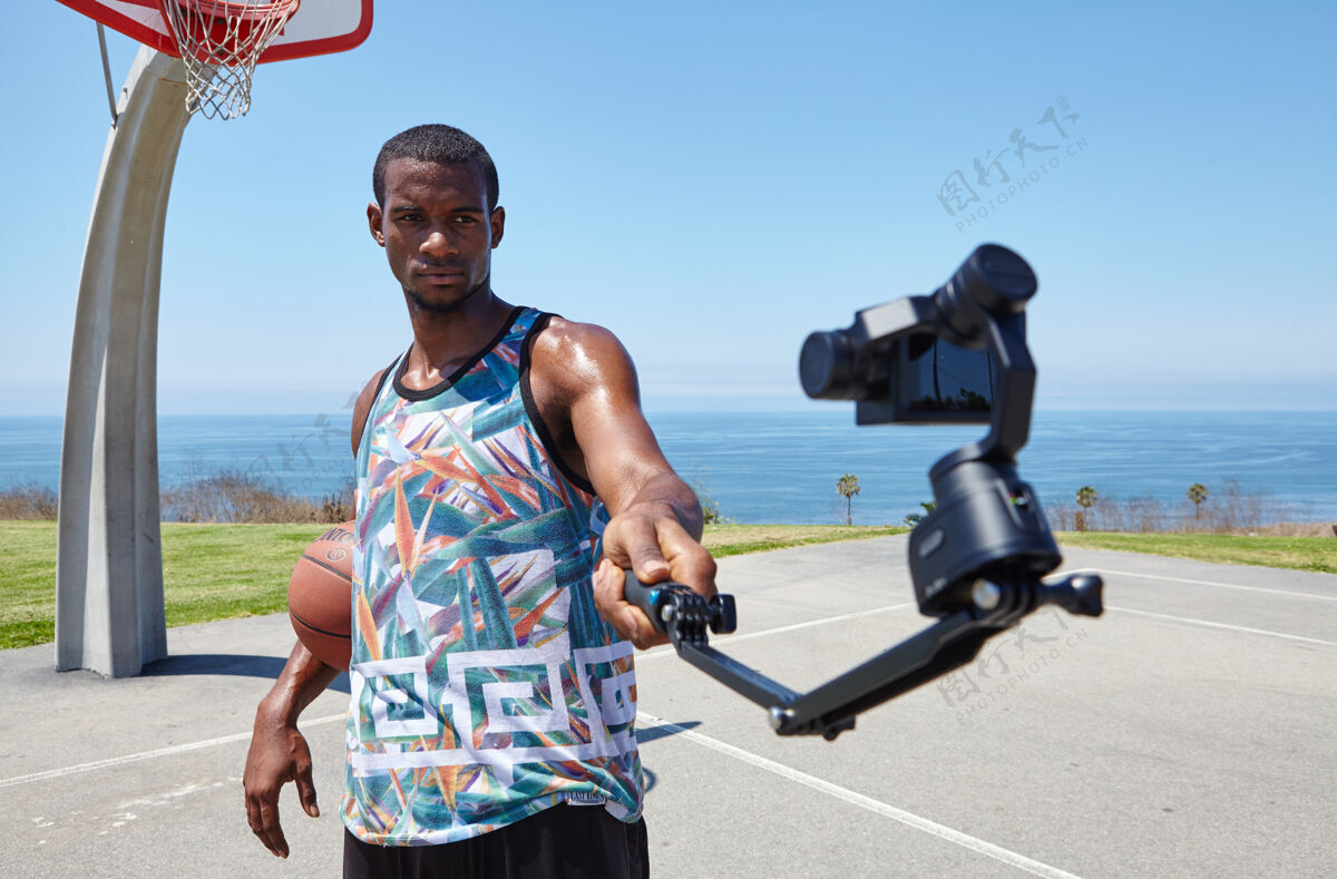 美国黑人篮球运动员在海边与自拍相机动作相机篮球太平洋