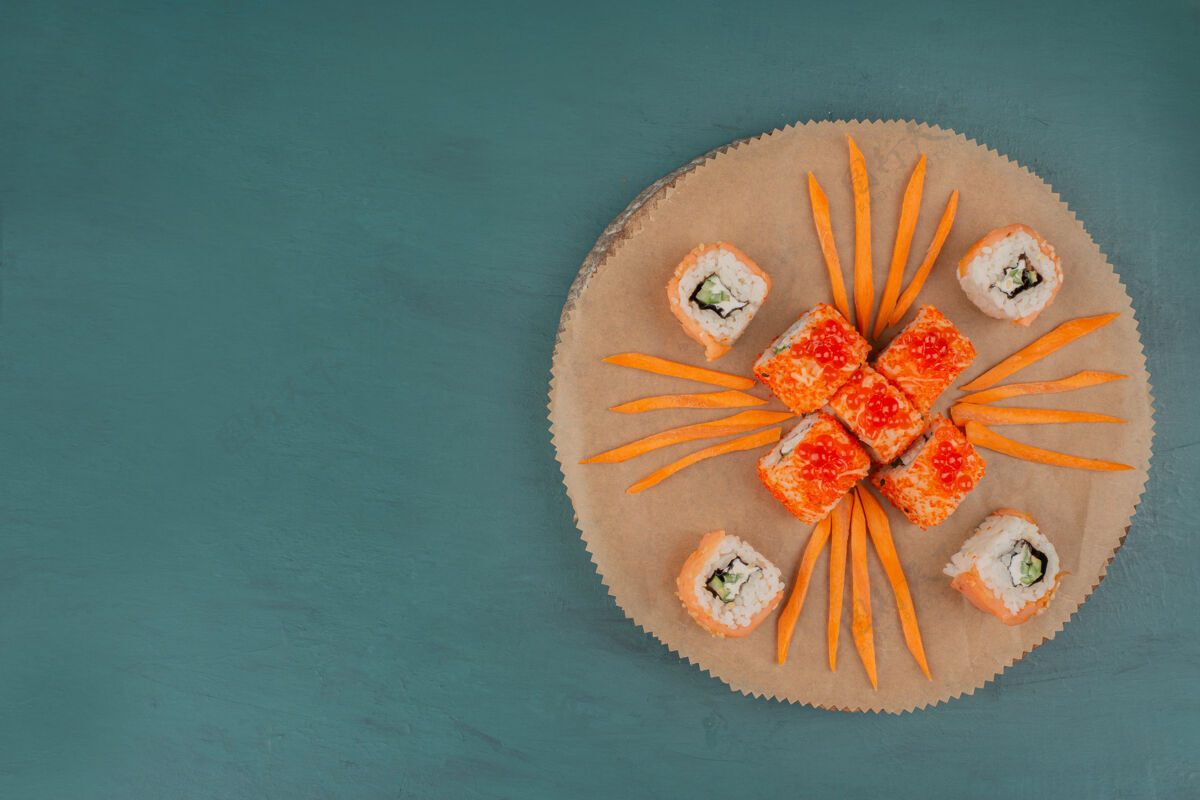 胡萝卜把寿司和胡萝卜片放在木板上搅拌顶视图寿司费城