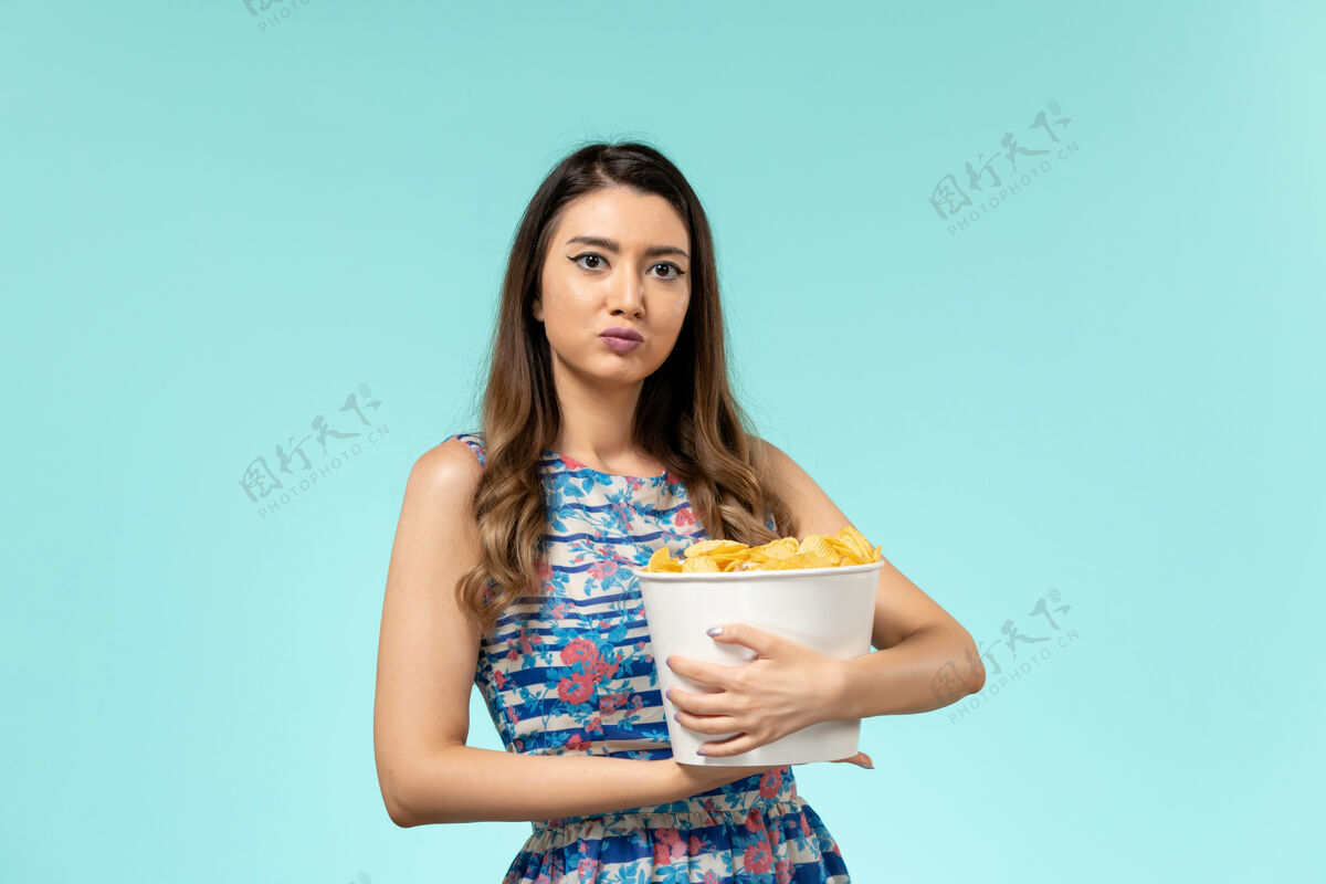 剧院正面图：年轻的女性拿着篮子和薯片 在蓝色的桌子上看电影女士年轻女性漂亮