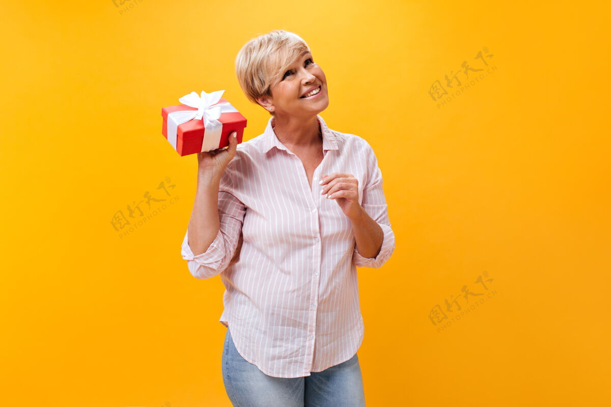 护理穿条纹衬衫的快乐女士与礼盒合影礼盒中年女性