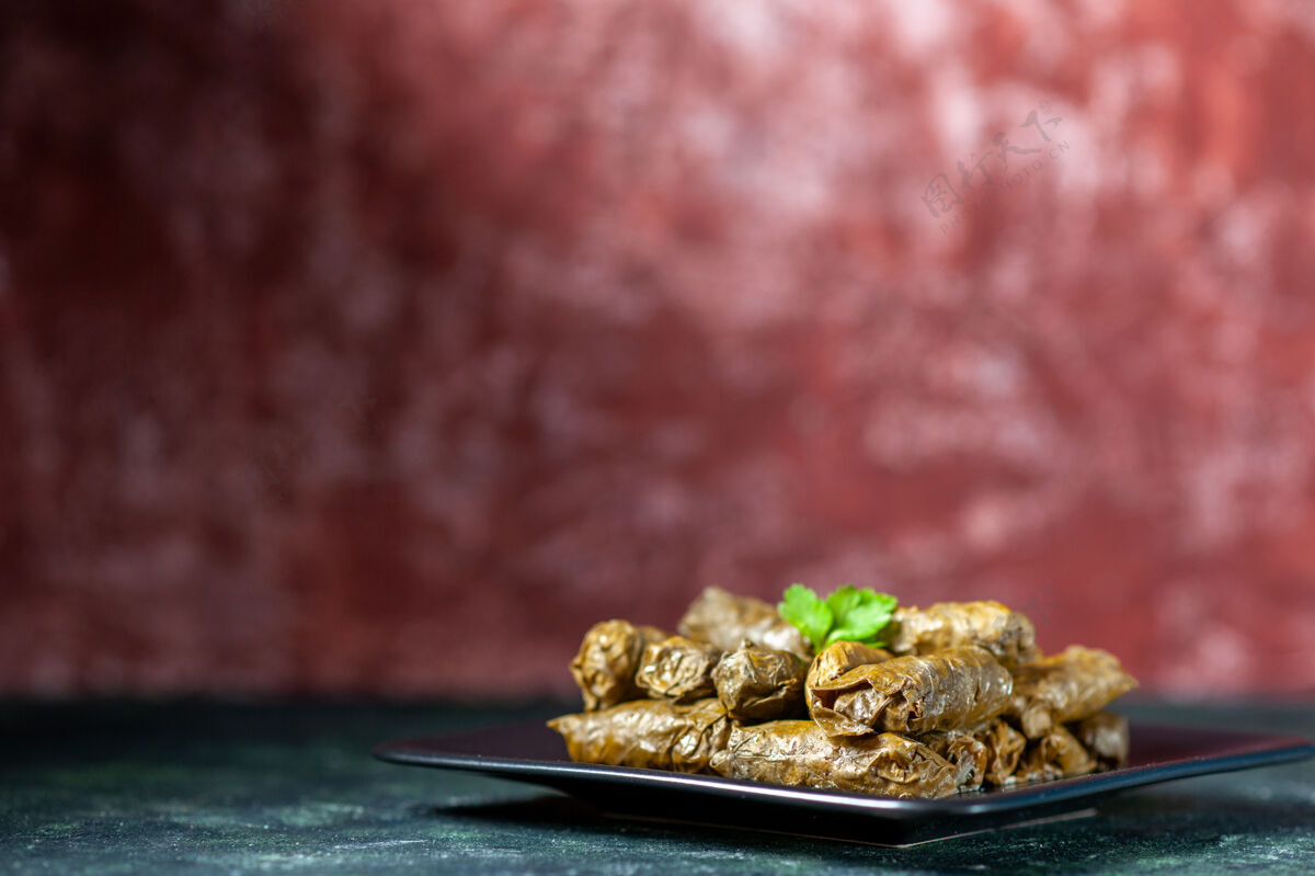 菜前视图美味的叶子dolma内板上的深色背景卡路里油晚餐餐厅餐沙拉菜肉盘子菜肉