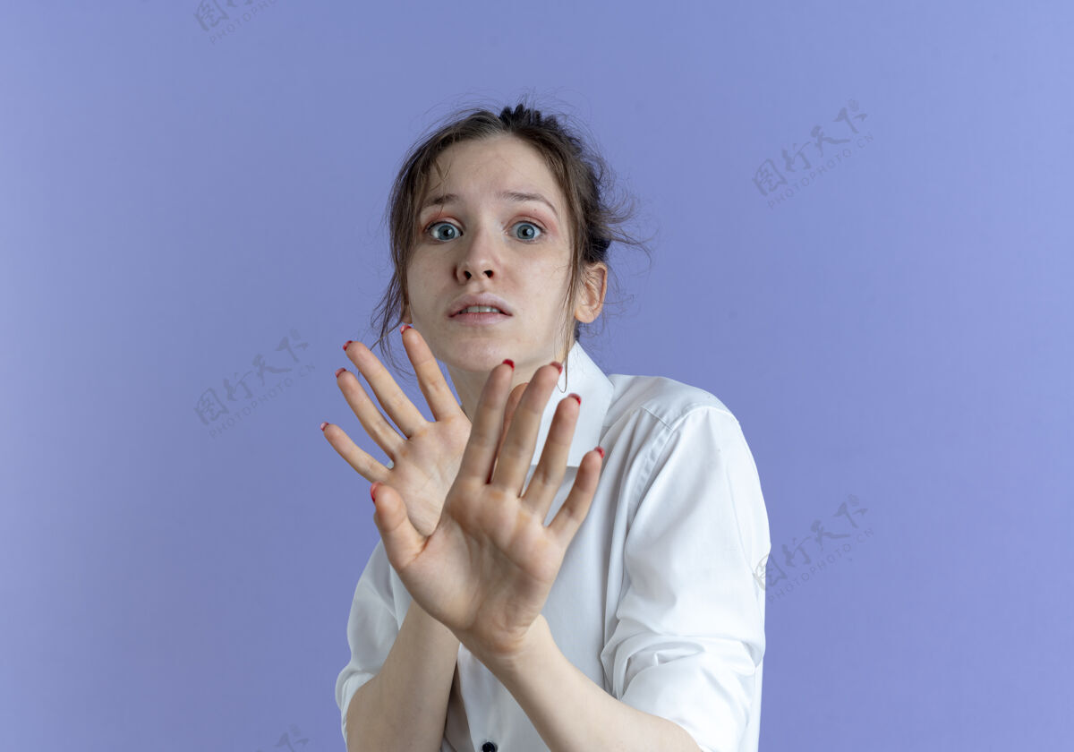 俄罗斯年轻吓坏了的金发俄罗斯女孩用手在紫色的空间和复制空间隔离防守害怕手金发
