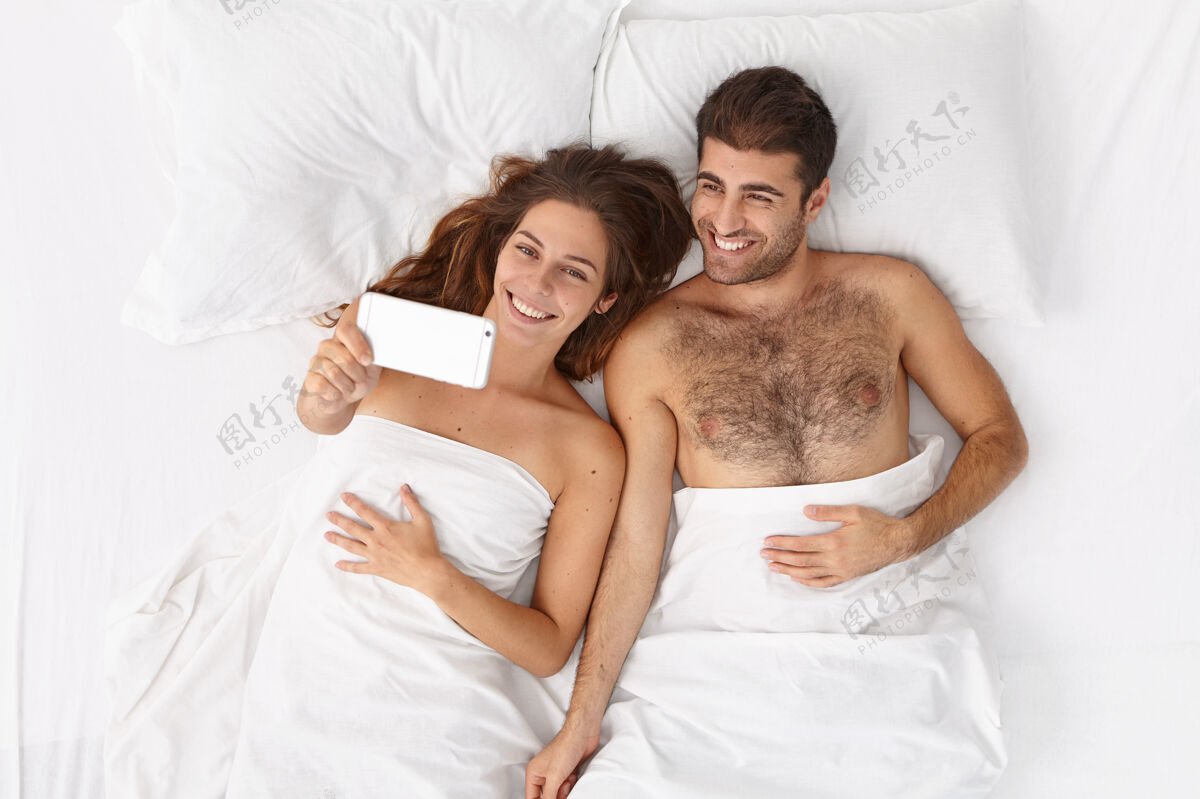 拍摄特写这对躺在床上白毯子下的夫妇女人毯子舒适