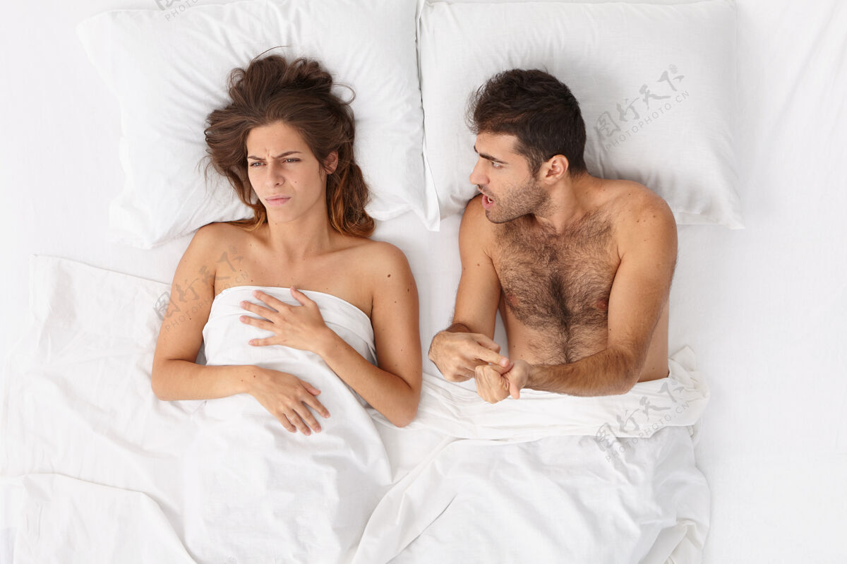 压力特写这对躺在床上白毯子下的夫妇男朋友冲突伙伴关系