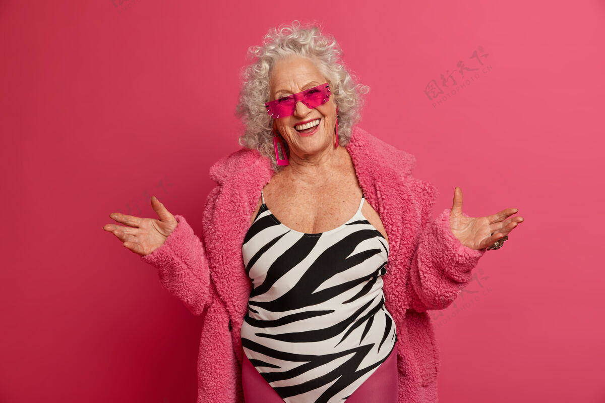女穿着粉色紧身衣和外套 满脸皱纹的时尚老奶奶的特写照片人微笑年龄