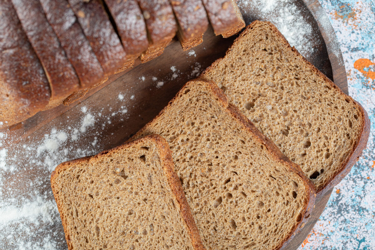 吃把几片棕色的面包片放在木盘上烹饪新鲜美味
