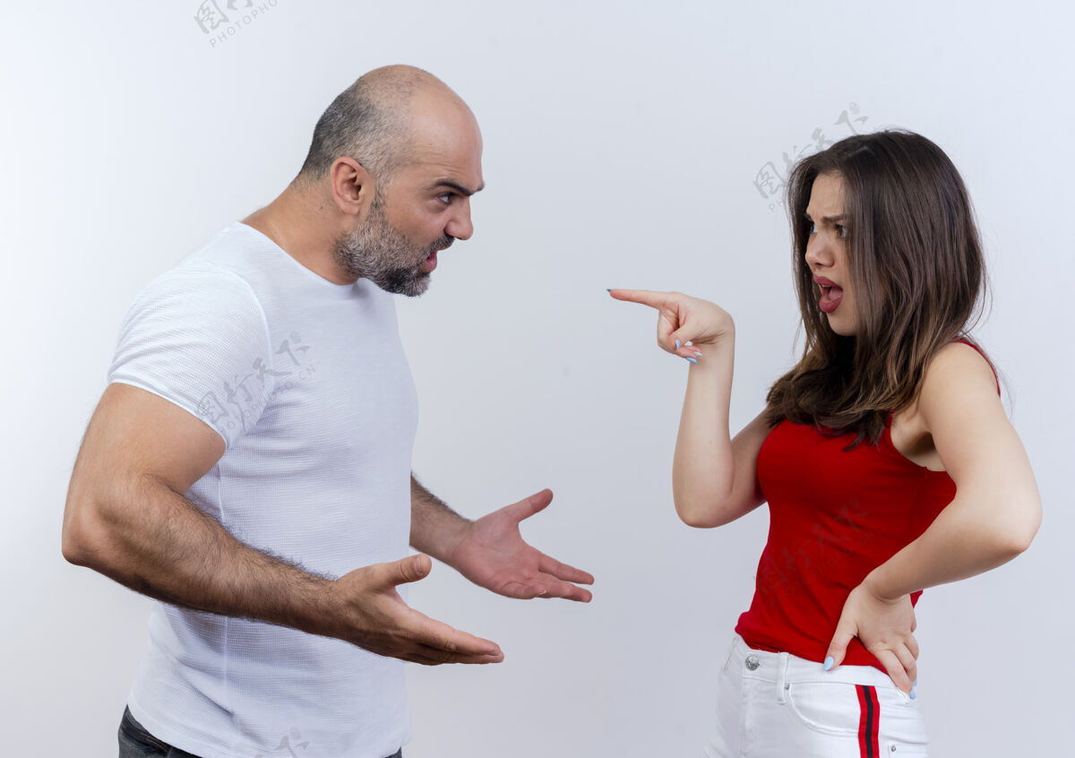争论愤怒的成年夫妇互相争吵 男人摊开双手 女人把手放在腰上 指着隔离在白墙上的他每个传播指点
