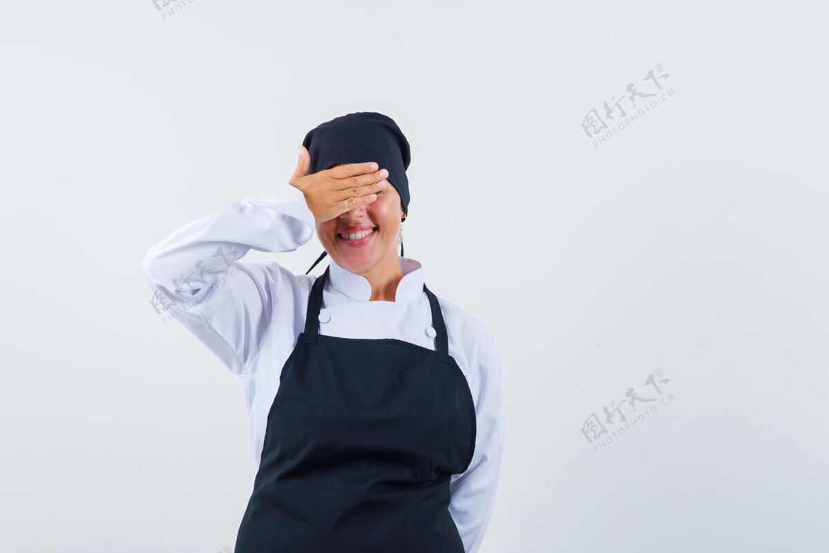 眼睛穿着黑色厨师制服的金发女人用手捂住眼睛 看上去很胆小手模特制服
