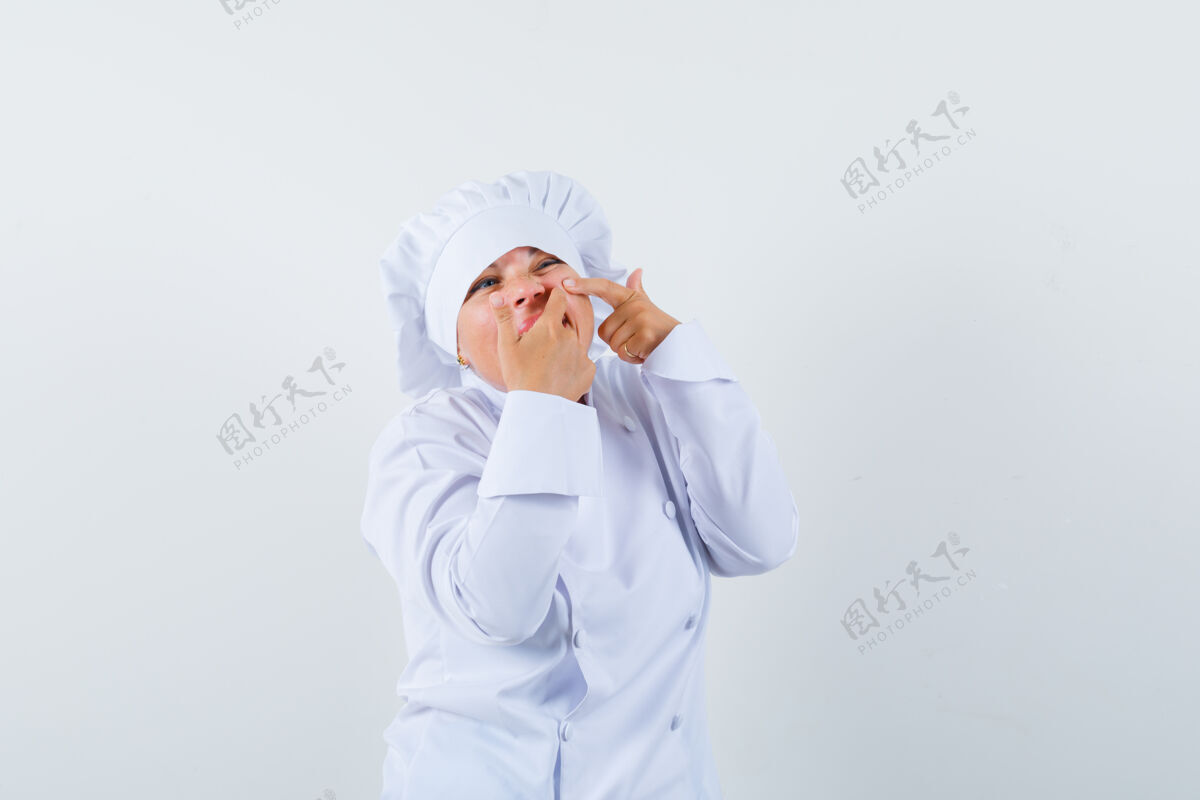 欢呼一个穿着白色制服的女厨师在脸颊上挤痘痘年轻粉刺休闲