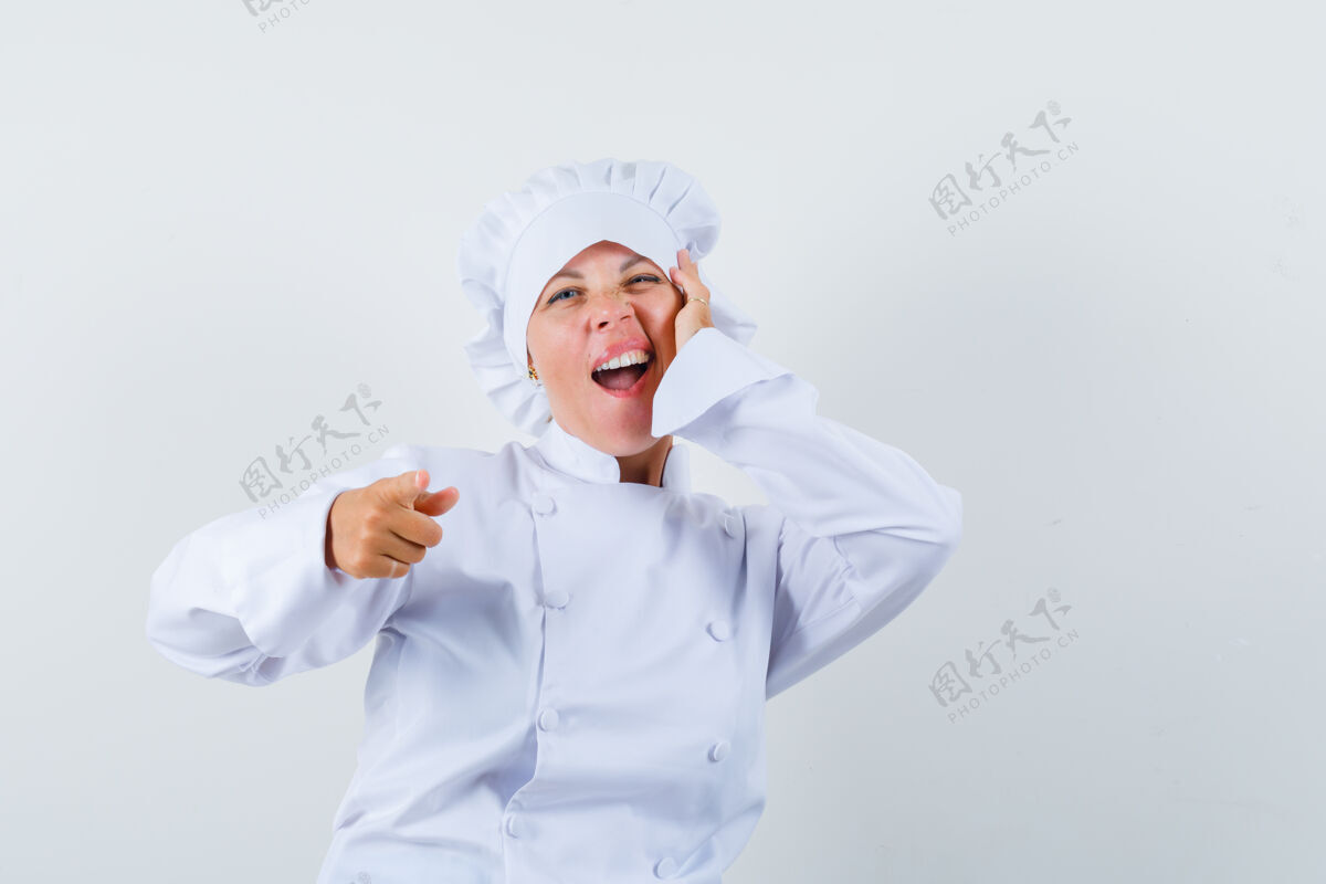 卷发女厨师指着前面 手放在脸颊上 穿着白色制服女士休闲制服