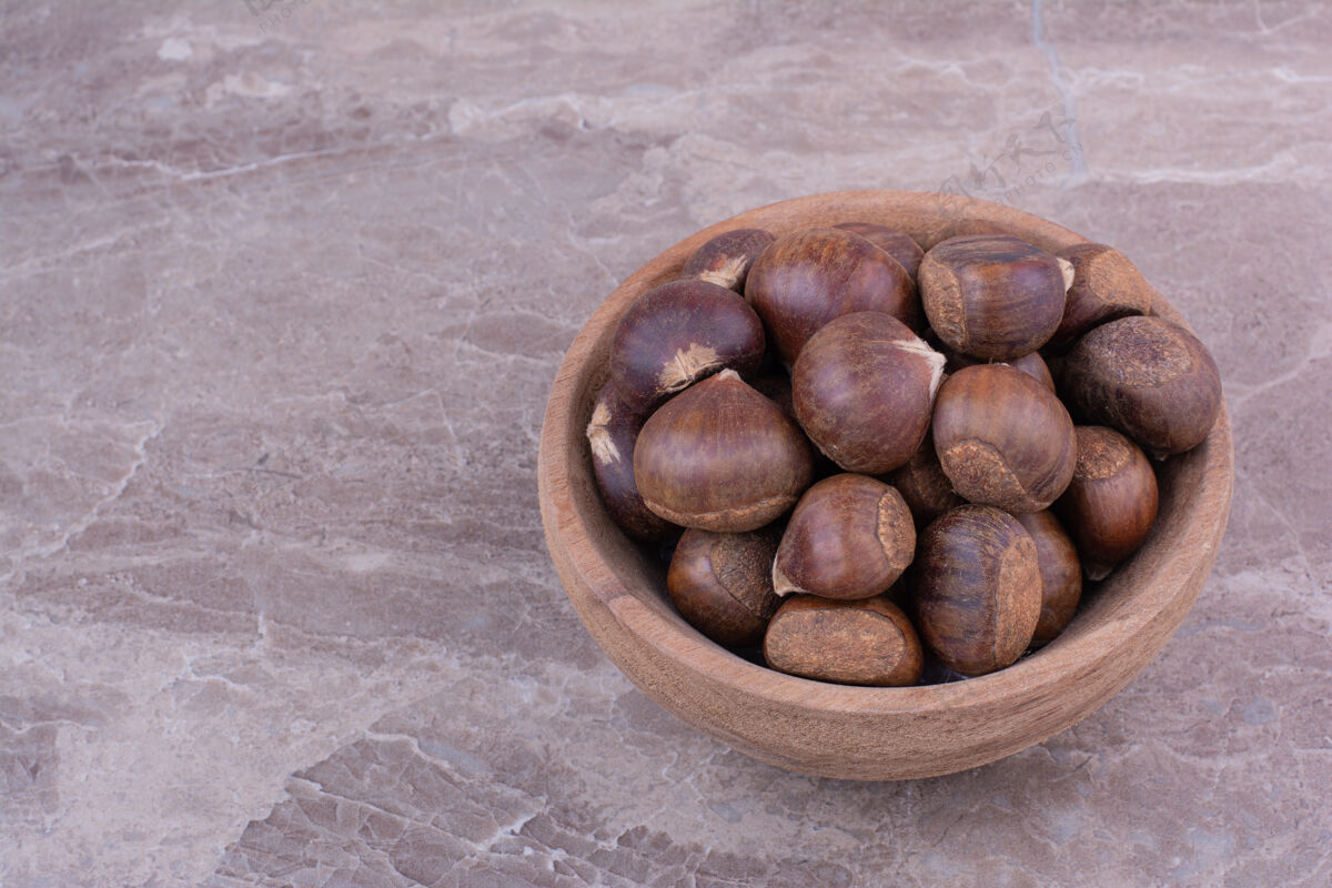 蔬菜棕色的栗子放在一个木杯上的石头上新鲜热带素食