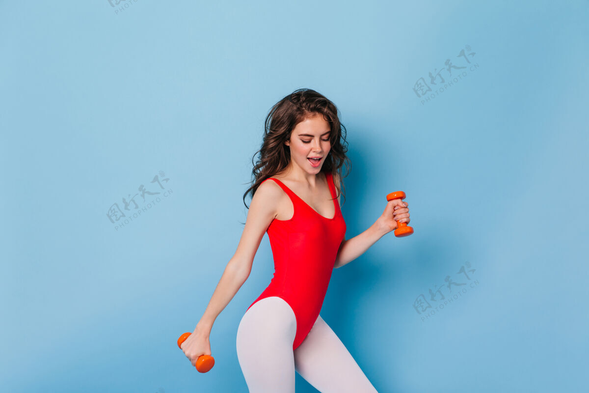健康穿着80年代风格的连体衣的年轻女运动员锻炼肱二头肌姿势身材女人
