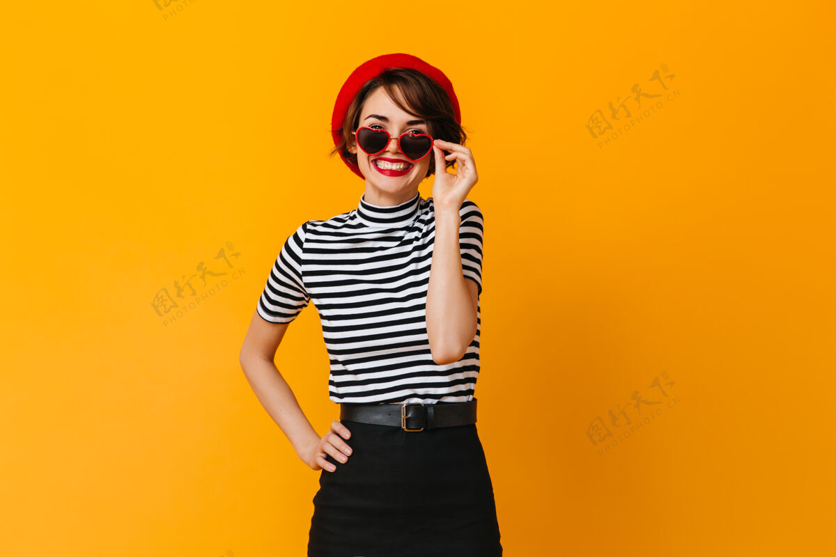 年轻心醉神迷的法国女人戴贝雷帽和心形太阳镜休闲情感时尚