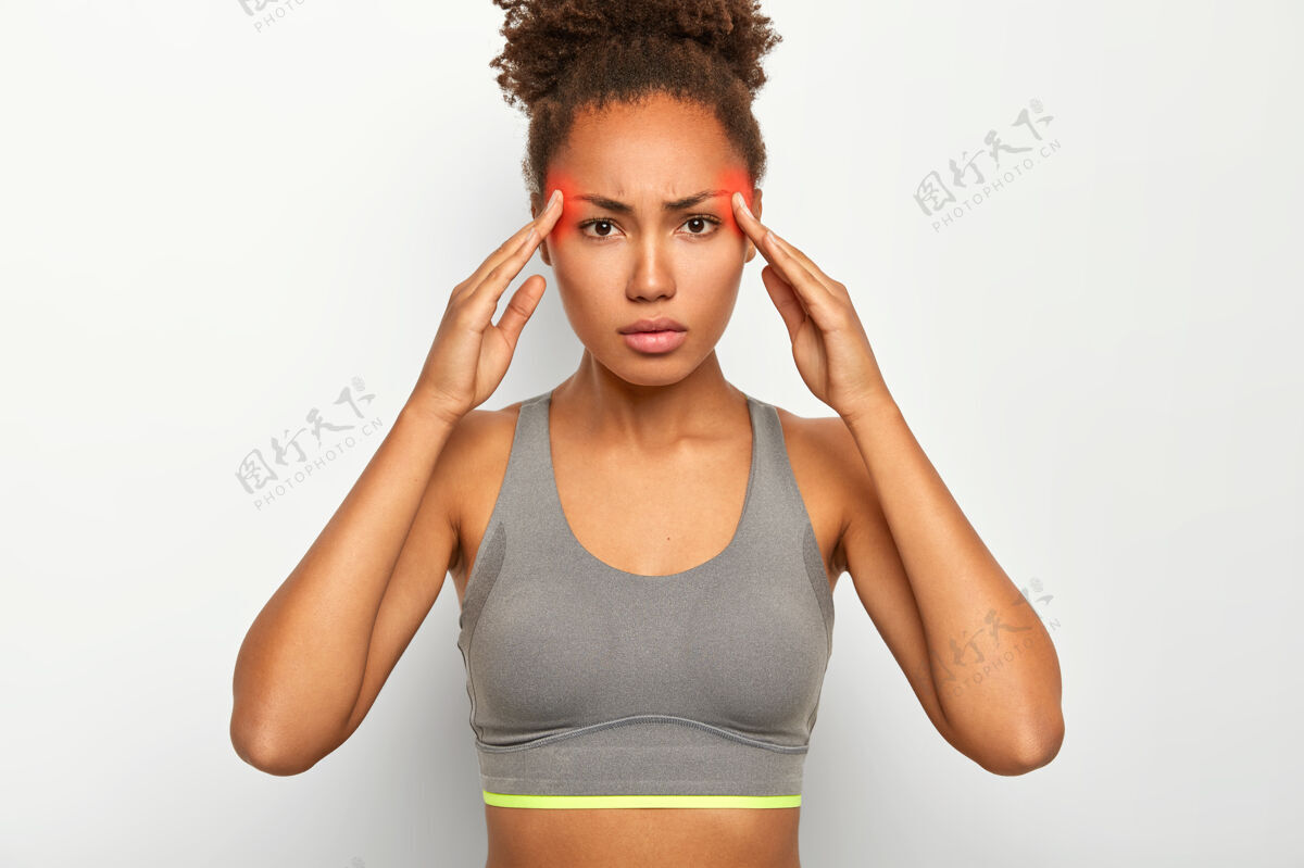 人严肃的女人摸两个太阳穴 患有偏头痛 穿着灰色上衣 头上有红色标记区域显示疼痛区域感觉休闲痛苦