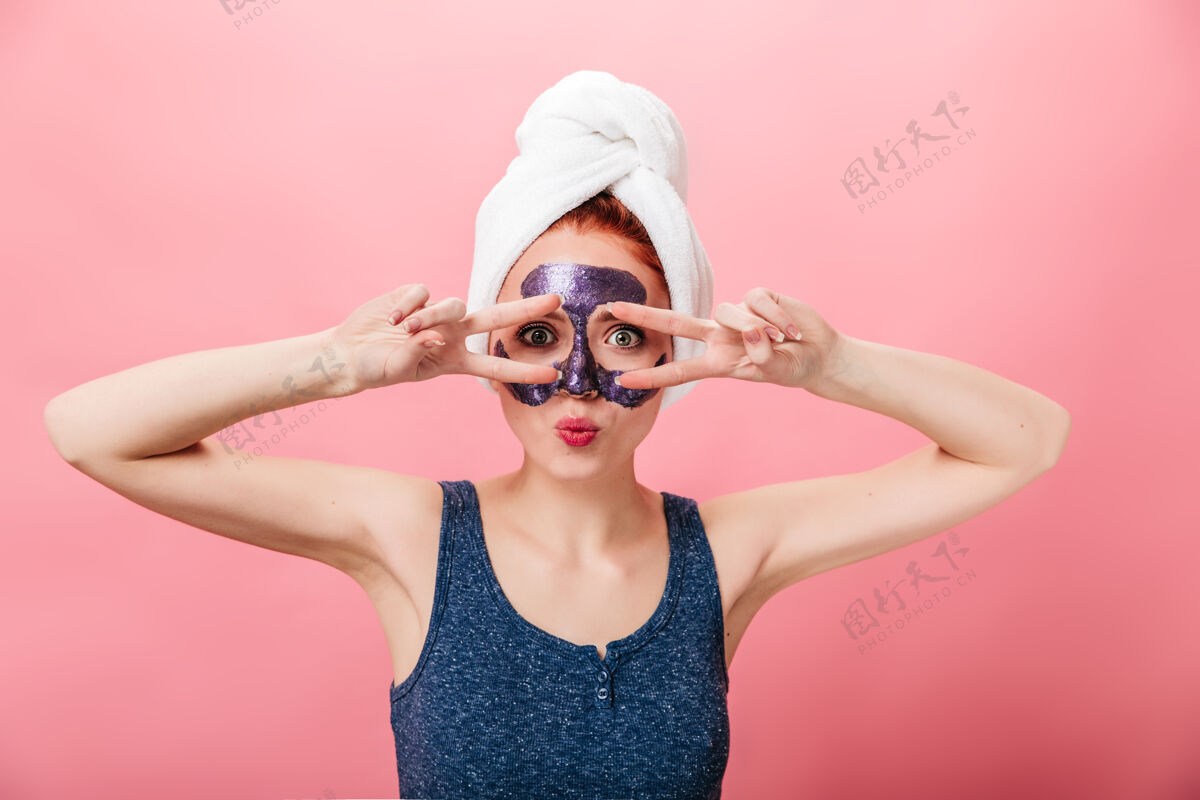 脸有趣的女孩头巾显示和平标志前视图迷人的女人做护肤品在粉红色背景上孤立处理工作室拍摄享受皮肤护理年轻人
