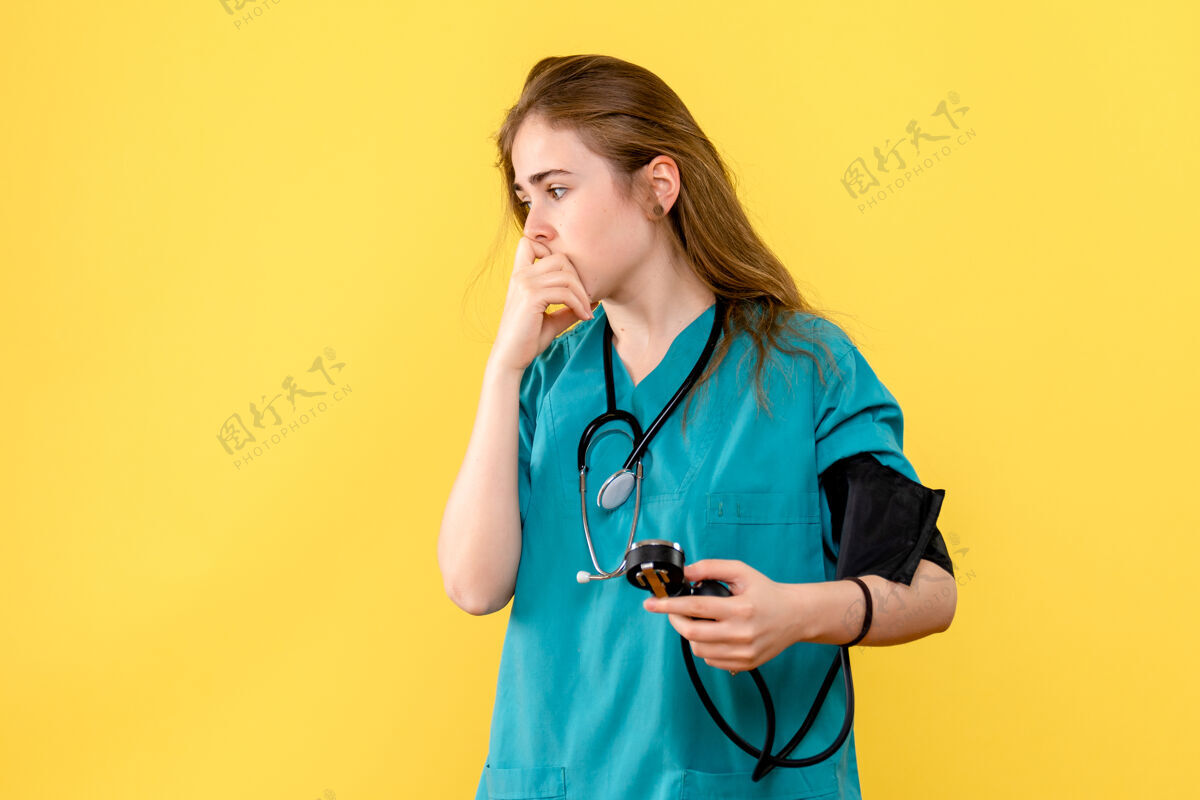 设备前视图女医生在浅黄色背景上测量压力医疗卫生院医药护士听诊器