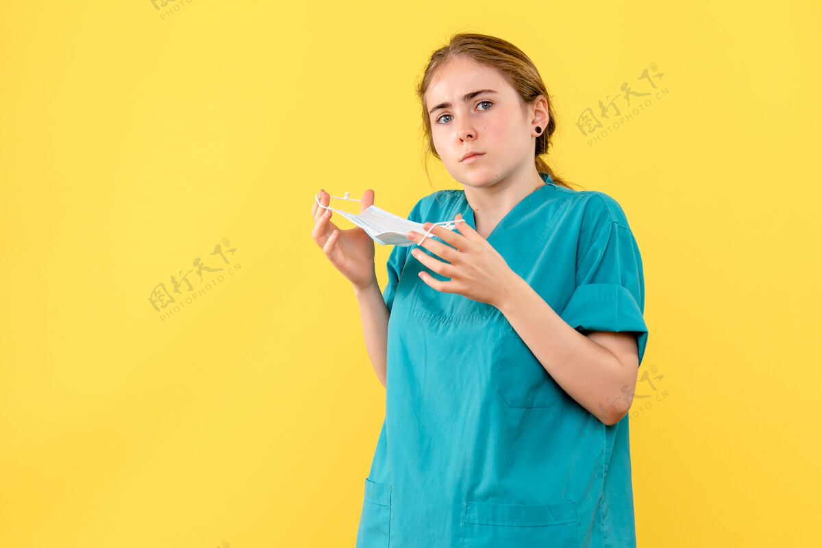 冠状病毒前视图女医生摘下黄色背景上的口罩大流行健康病毒covid长相病毒面具