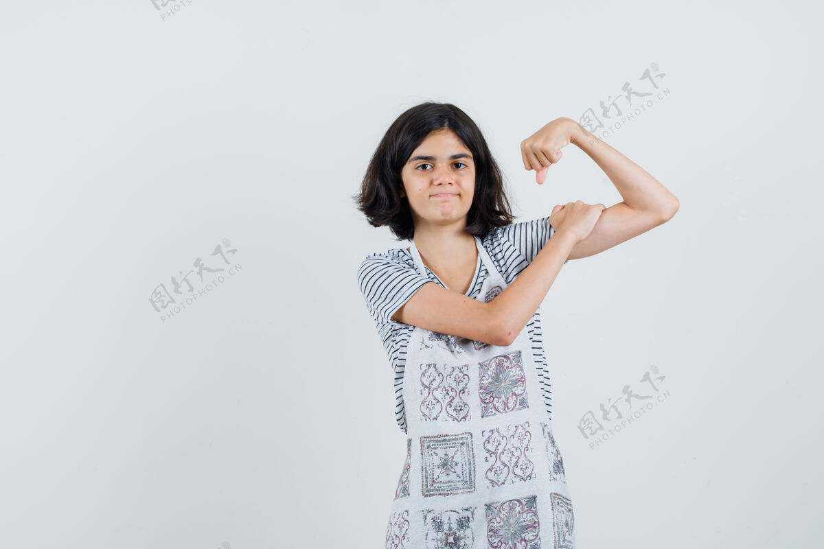 肌肉小女孩穿着t恤 围裙露出手臂的肌肉 看起来很自信 头发漂亮小