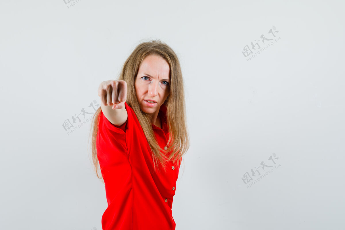 拳头一个穿着红衬衫的金发女人用拳头威胁 看起来很愤怒 愤怒魅力护理