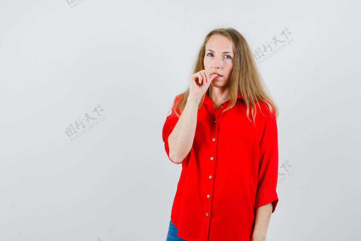 皮肤一个穿红衬衫的金发女人咬着指甲 看上去很体贴 漂亮护理金发