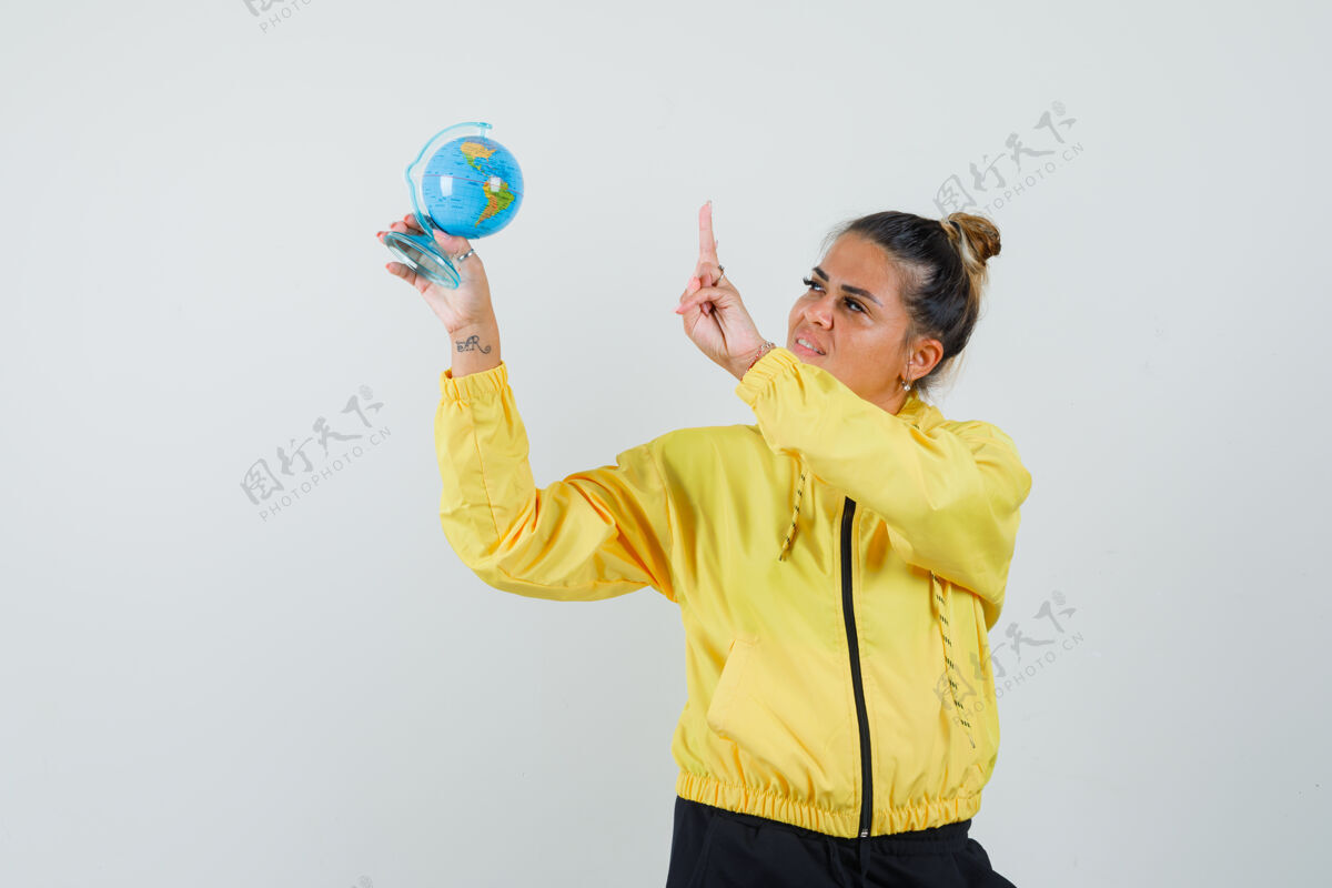 女人穿着运动服的女人拿着学校的地球仪 展示v形标志 正视图民族Vsign化妆