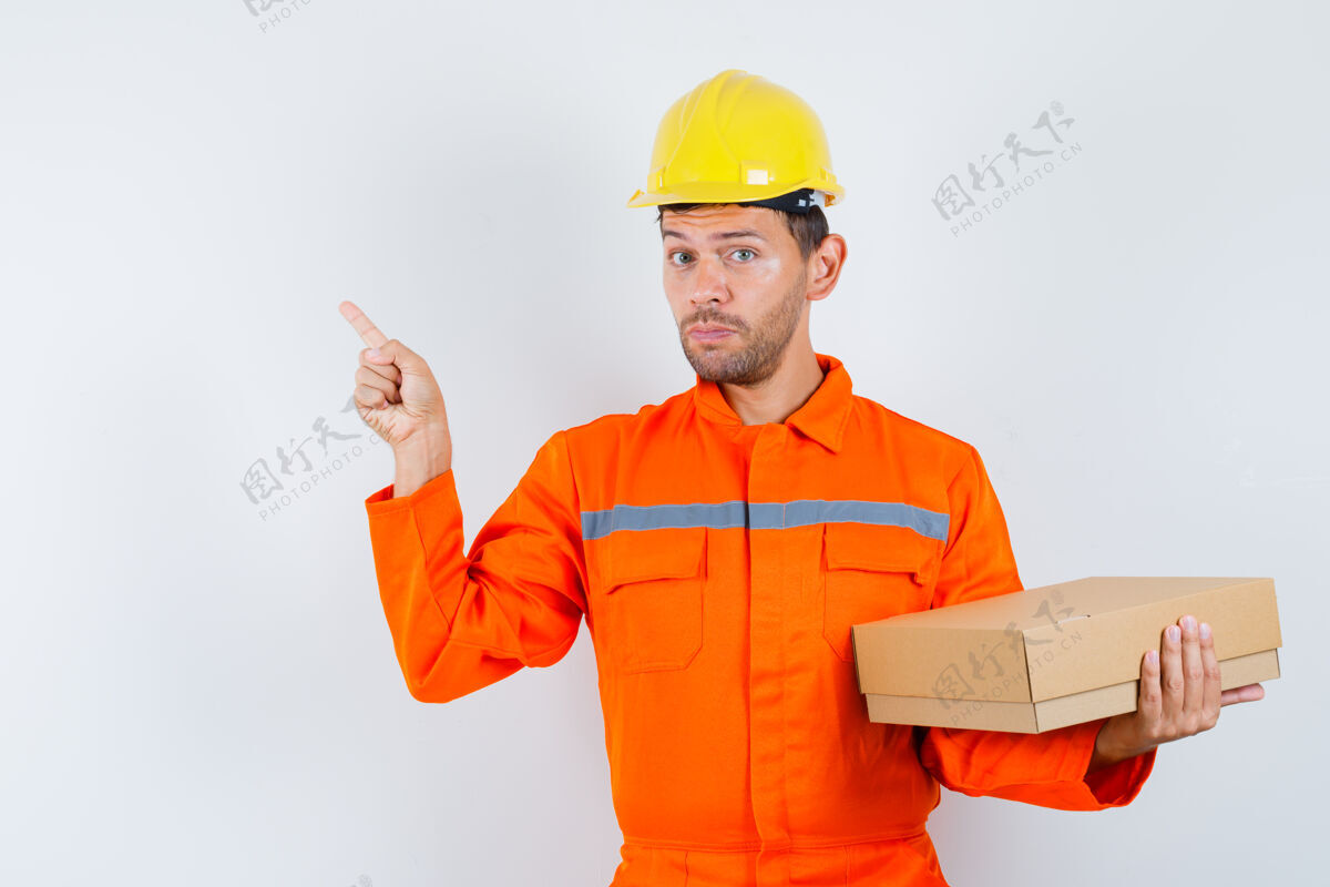 左建筑工人拿着纸板箱 指着左角的制服 头盔正对着勾缝现场制服
