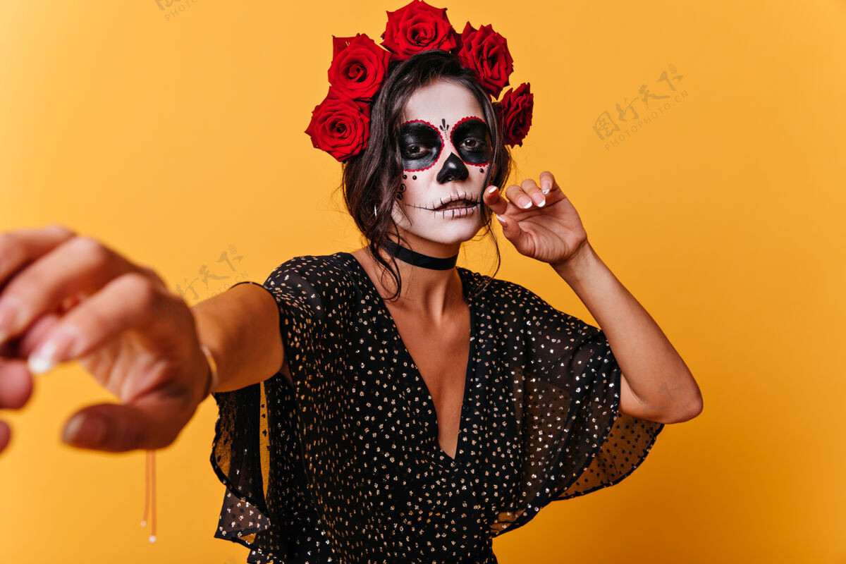 化妆愁眉苦脸的女孩 棕色眼睛 要求跟她走橙色墙上黑发墨西哥模特的画像民间传说恐怖年轻