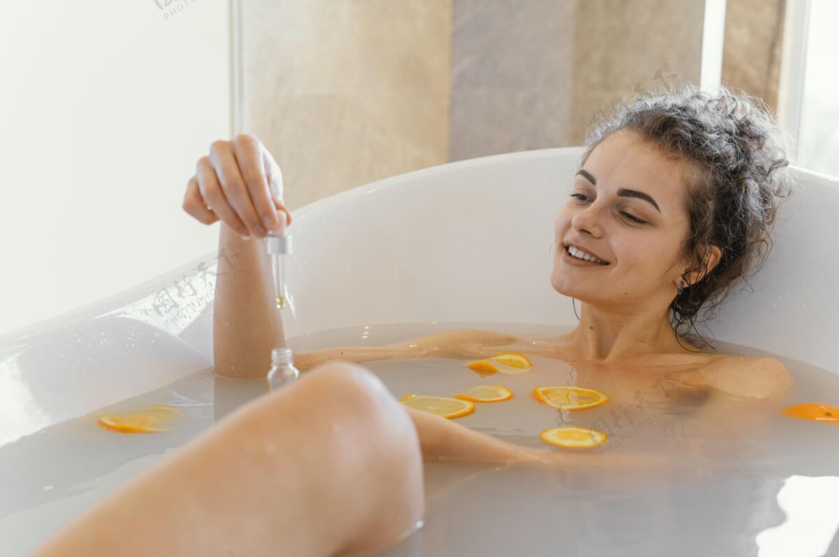 自我护理在浴缸里放松的女人用橘子片浴缸血清房子