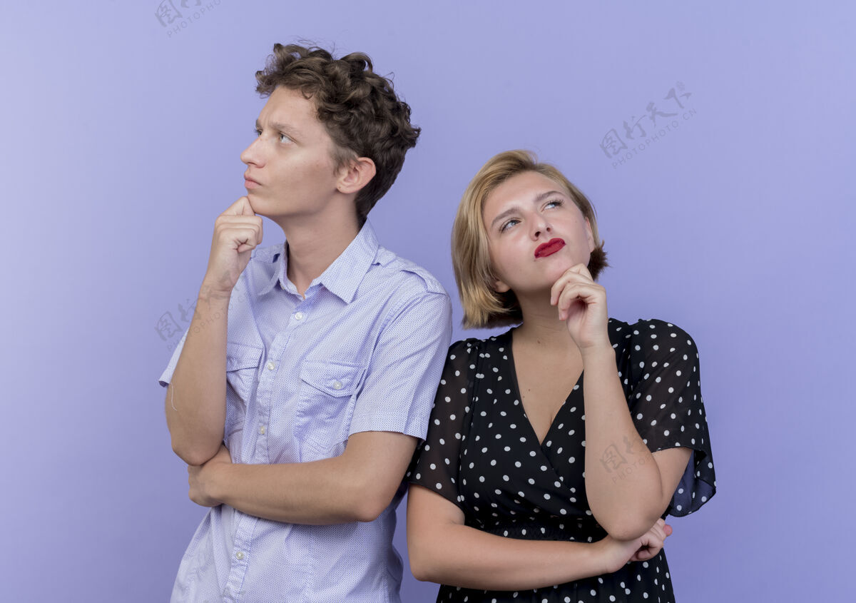 女人一对年轻漂亮的夫妇站在蓝色的墙上 脸上带着忧郁的表情站着脸夫妻