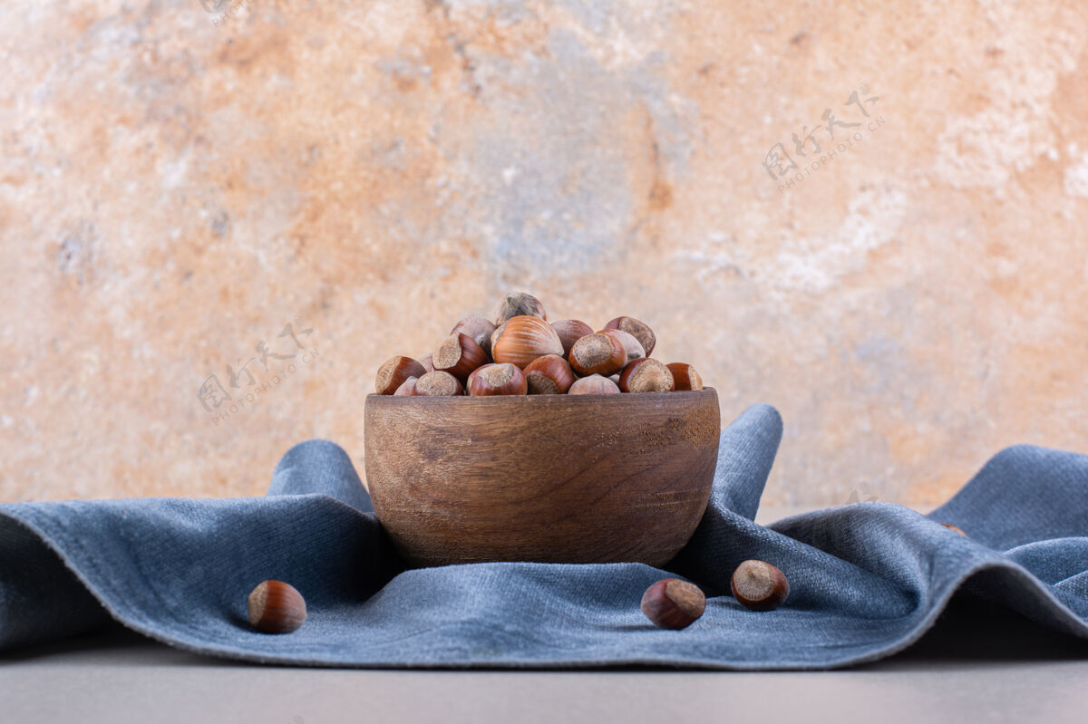 坚果壳蓝色布上有壳有机榛子木碗高品质照片生的美味有机
