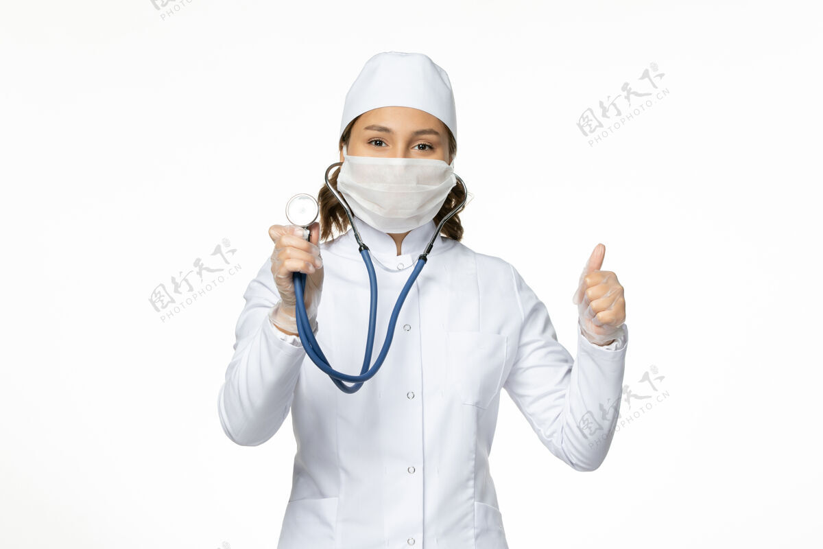 医院正面图女医生穿着白色医疗服 戴着口罩在白墙上用听诊器给潘多米病毒治病听诊器护士专业