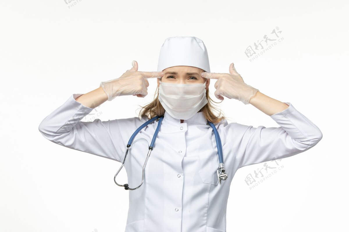 冠状病毒预防正面图女医生穿着医疗服 戴着无菌口罩 因白色办公桌上有冠状病毒病大流行性疾病冠状病毒-工作人到期