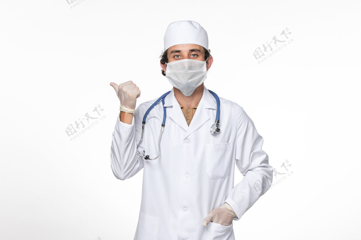 人正面图：男医生穿着医疗服 戴着口罩 以防白墙病毒溅起冠状病毒大流行大流行防护正面