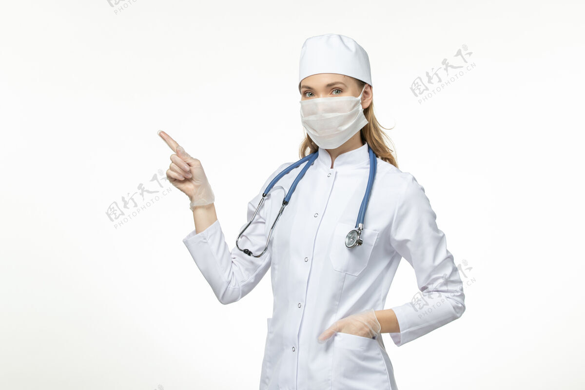 药品前视女医生身穿医疗服戴口罩因冠状病毒上桌淡白色疾病冠状病毒-大流行性疾病灯光医院佩戴