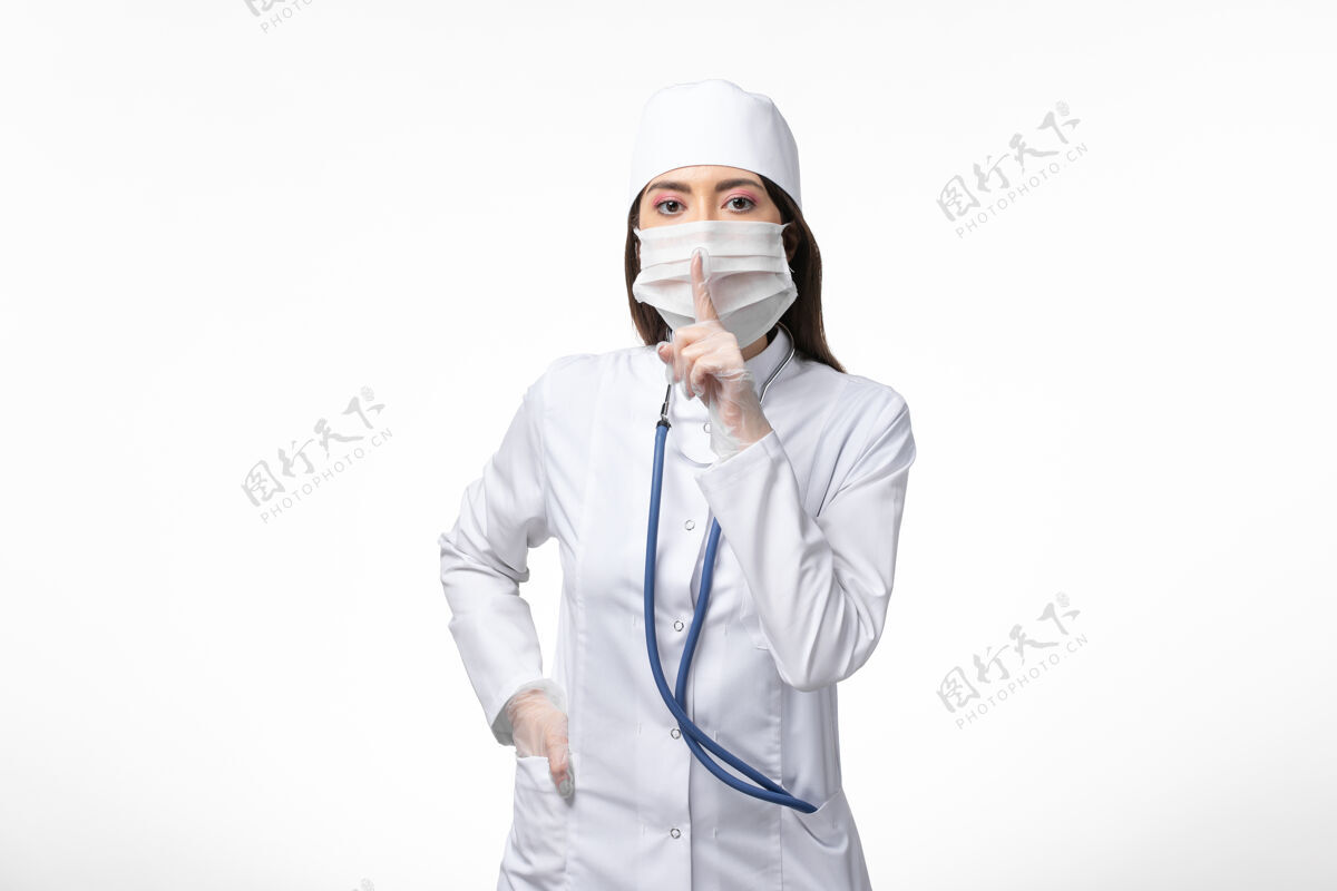 视图正面图：女医生穿着白色无菌医疗服 带着口罩 因为柯维德-白墙疾病-柯维德-大流行病毒疾病疾病到期冠状病毒